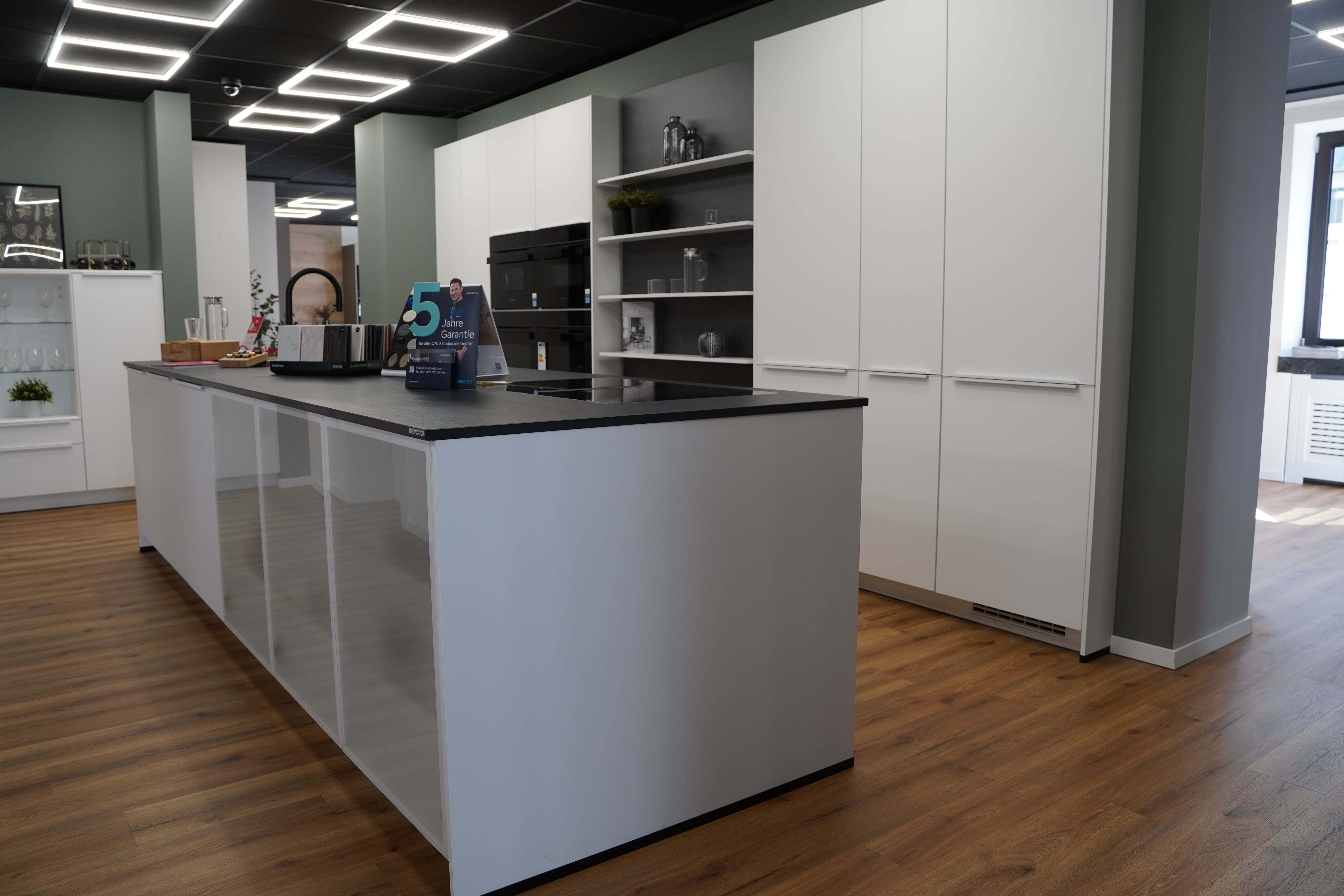 Moderne weiße Küche mit Kücheninsel und Schrankwand