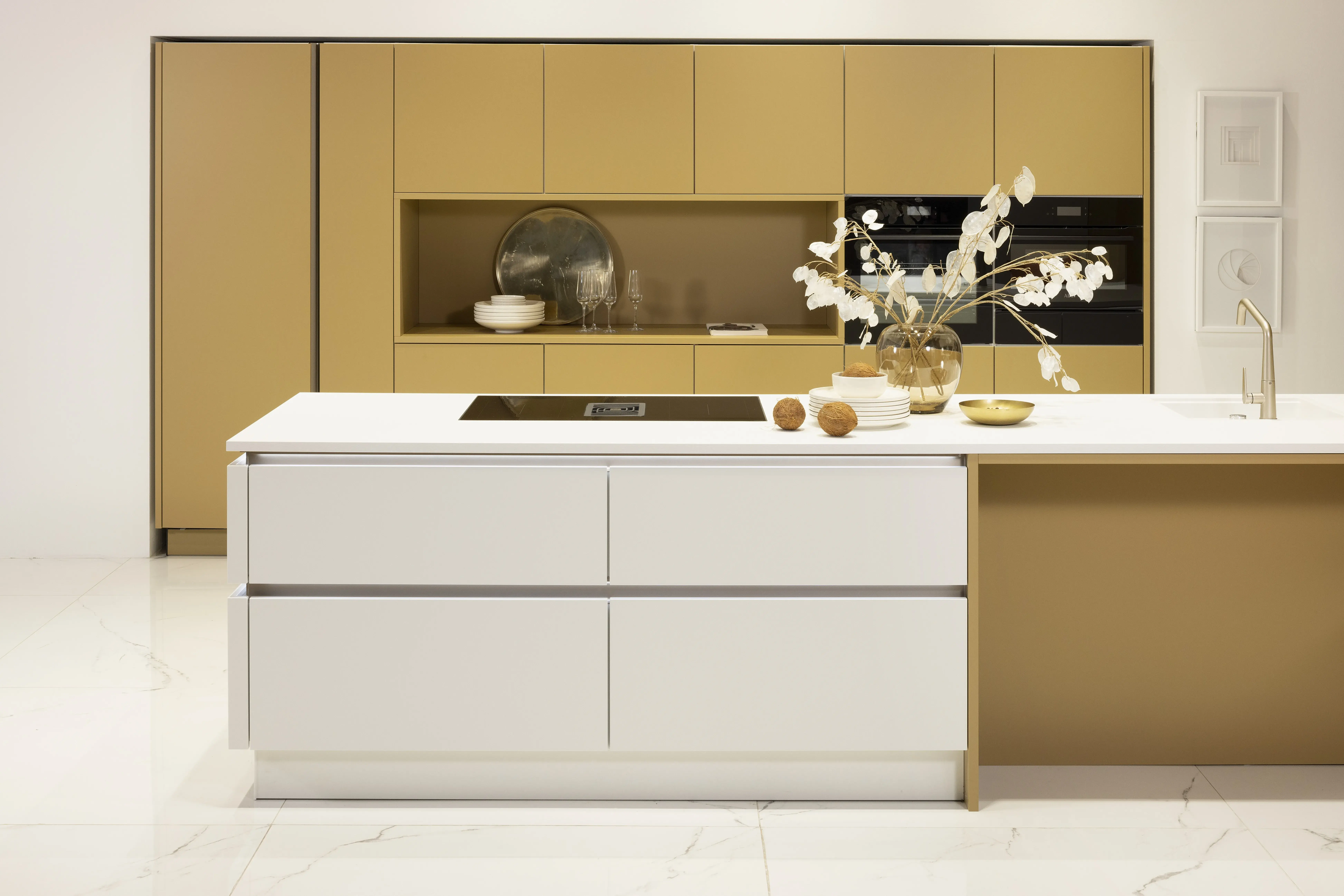 APL: Weiß Pro 25 mm Front: SoftLack Weiß softmatt Front: SoftLack Caramel softmatt Korpus: Weiß Griff: Kehlleiste Edelstahloptik, und PTO Geräte: AEG, Downdraft Faber Armatur: Gesi Spüle: elleci   Features: eingekoffertes Schrankelement mit integrierter Nische, Thema softmatt, Kompaktbackofen mit Wärmeschublade, Griffleiste beleuchtet, durchgehende Linienführung an Insellösung, Wandfarbe in Caramel wie Frontfarbe, Regale in Frontfarbe, Sitzbank mit Unterschränken, Marmorfliesenboden.