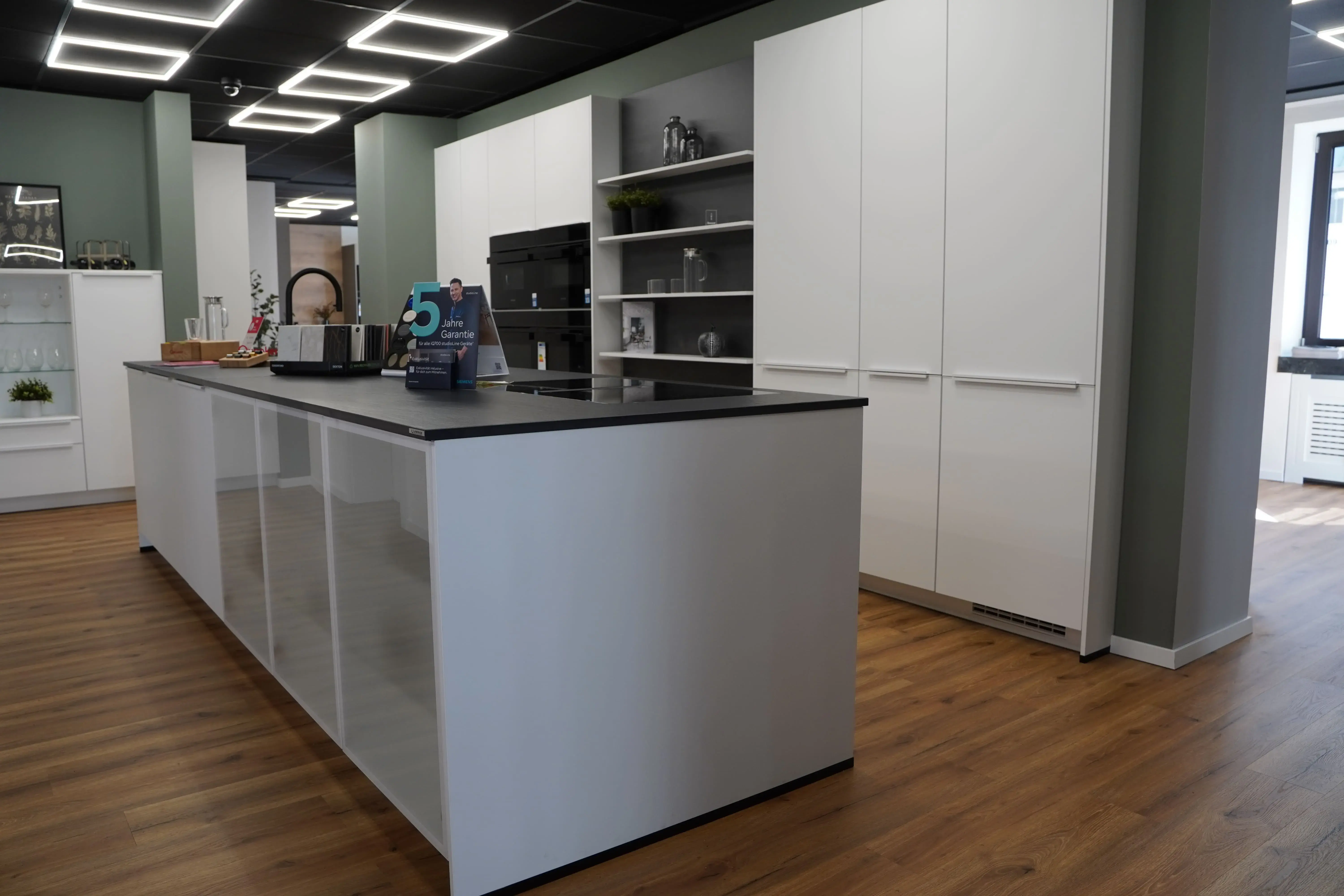 Moderne weiße Küche mit Kücheninsel und Schrankwand