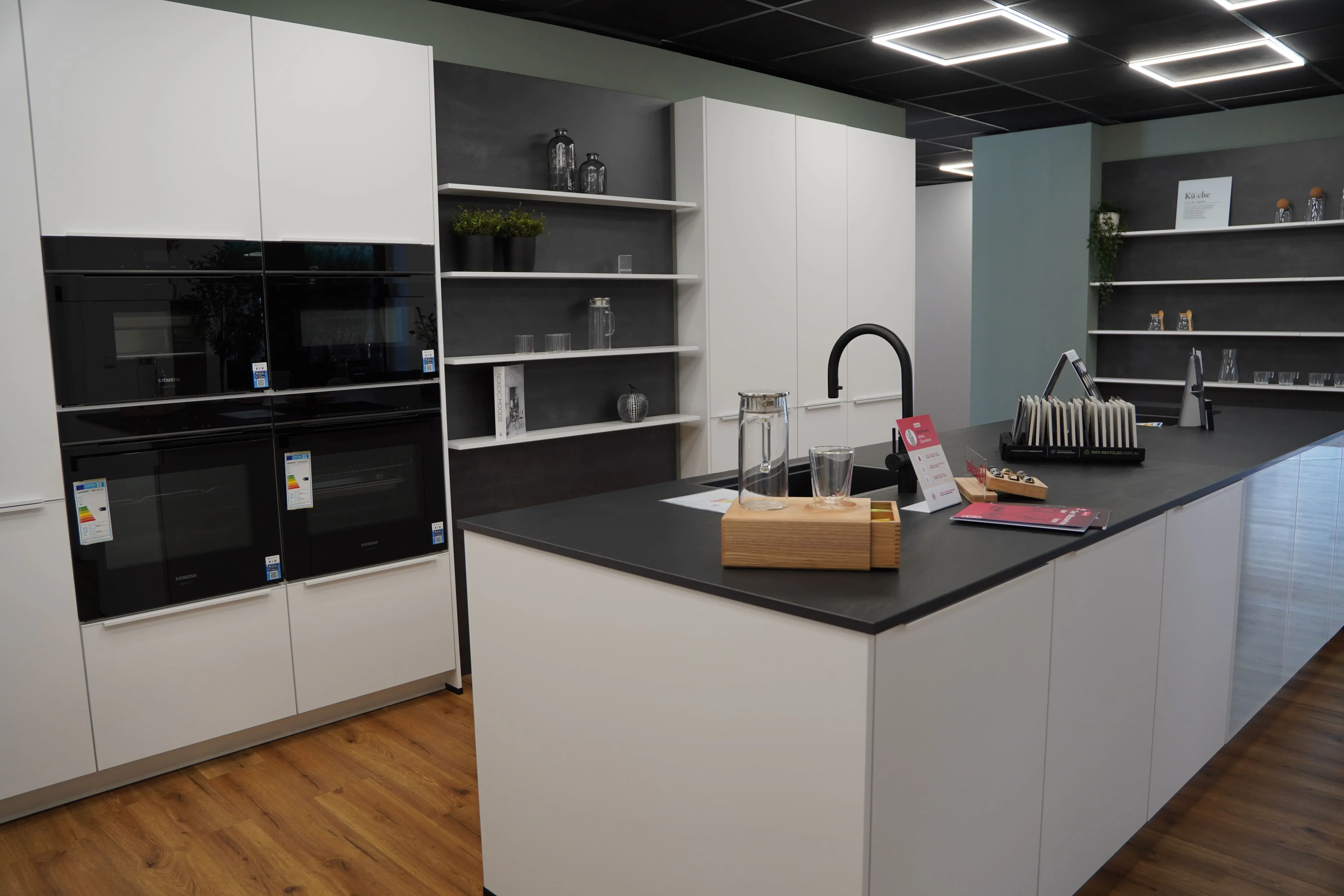 weiße Küche mit dunkler Arbeitsplatte und Kücheninsel